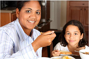 child and mother eating breakfast